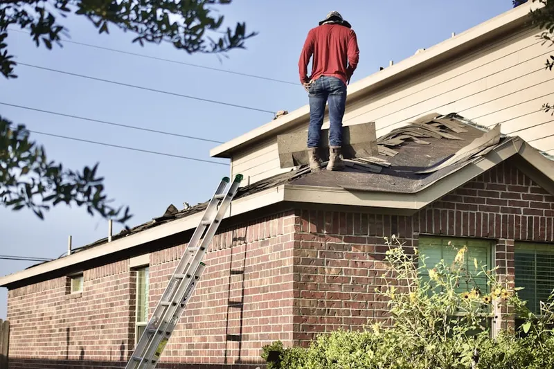 Professional roofer working on a residential roof in Town N County Park